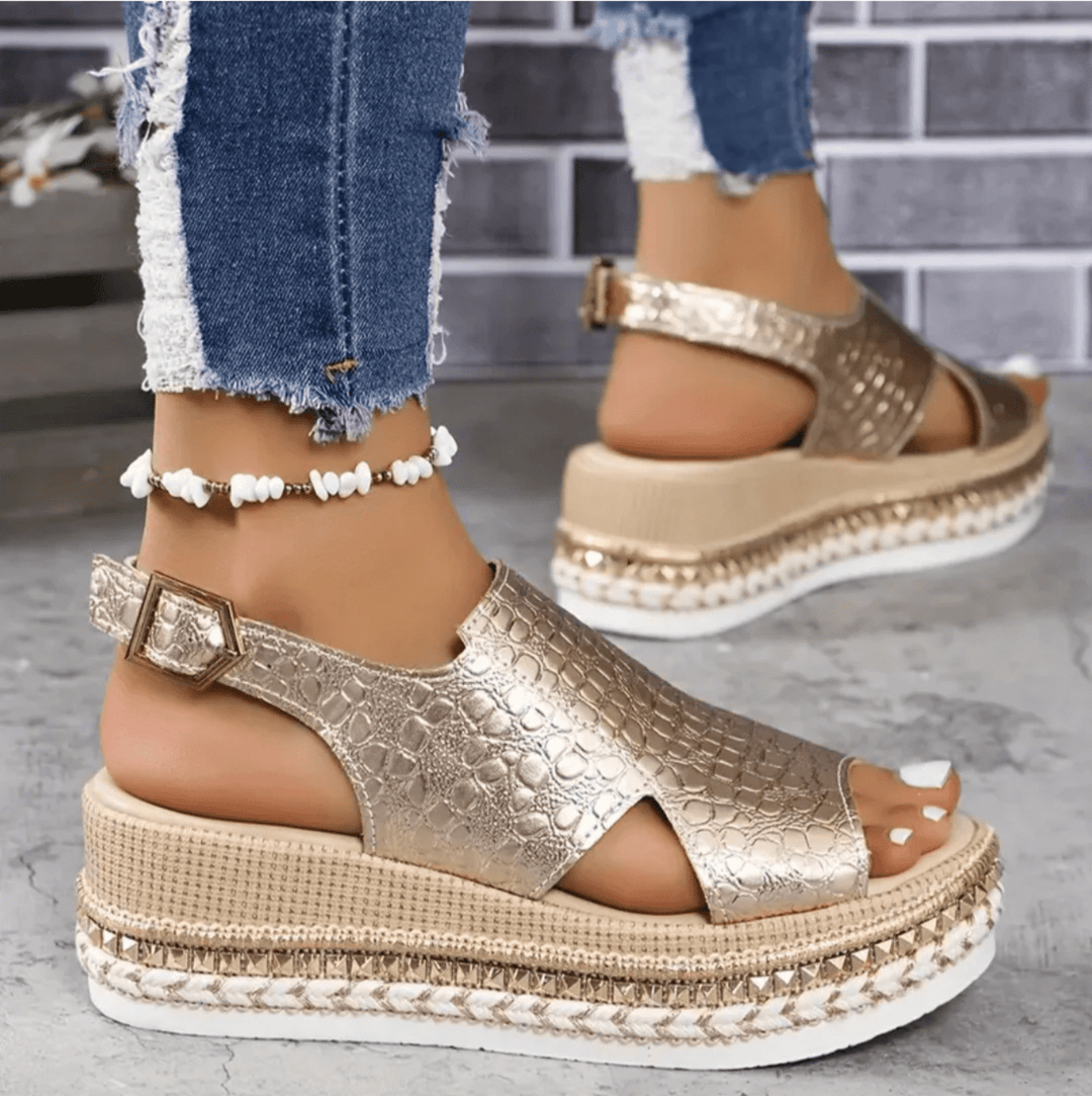Side profile of women’s heeled sandal on plain background.