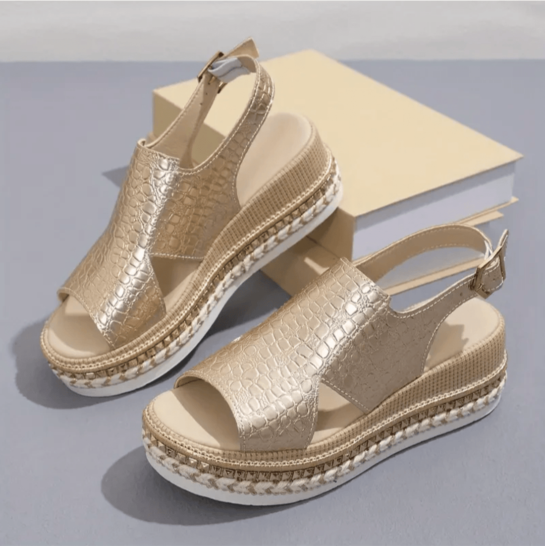 Angled top view of women’s sandal on plain background.