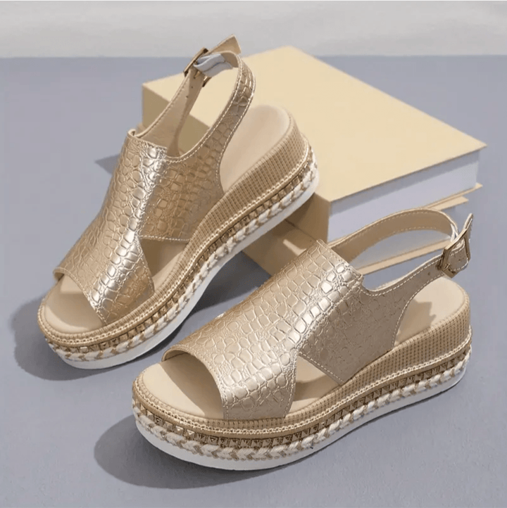 Angled top view of women’s sandal on plain background.