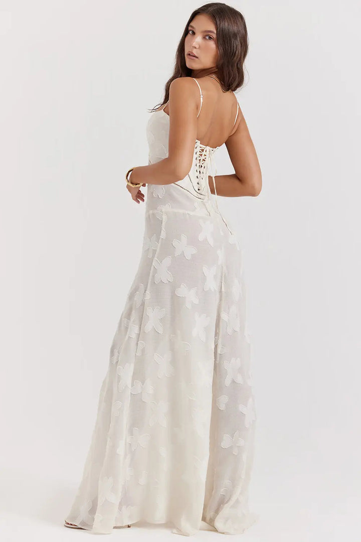 Woman standing in a lightweight maxi dress with adjustable straps on a plain background.