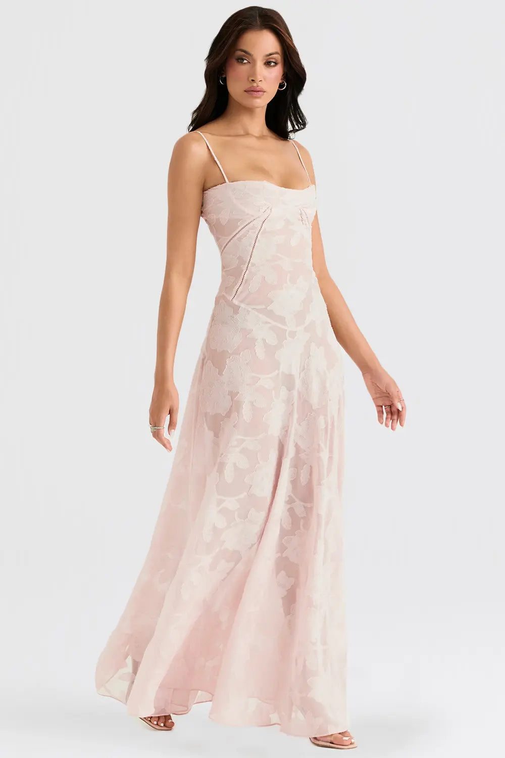 Backless summer maxi dress worn by a woman on a plain studio background.