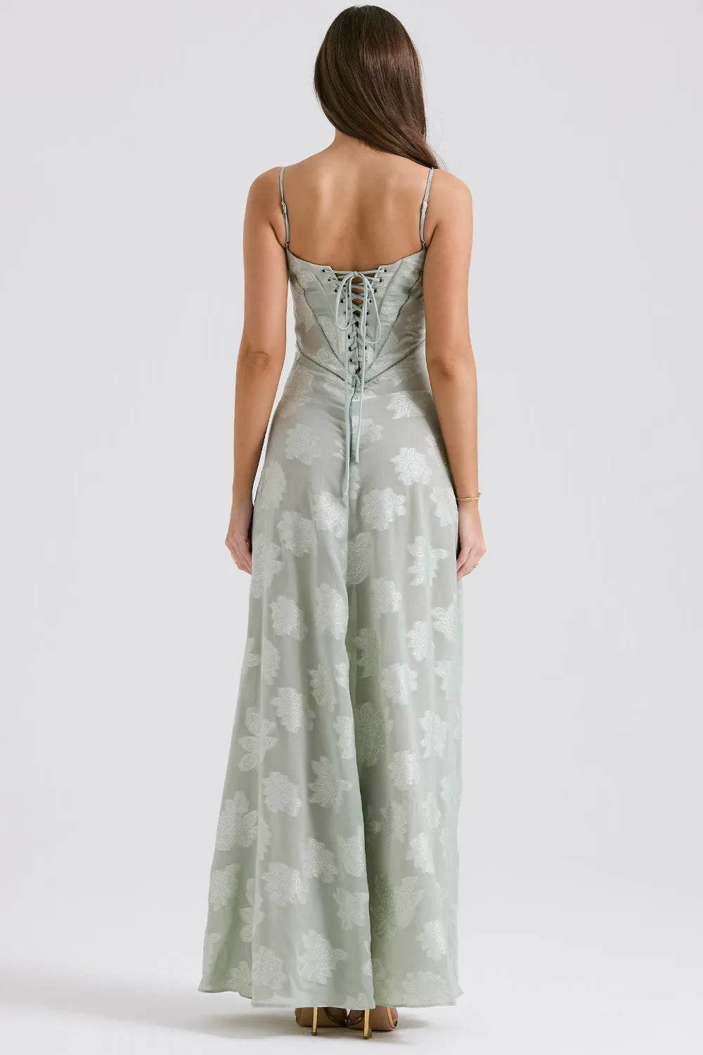 Elegant sleeveless maxi dress displayed on a woman with a plain backdrop, back view