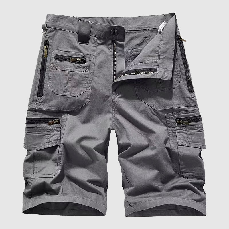  Female model wearing rugged utility pants with flap and zip pockets on a plain background.