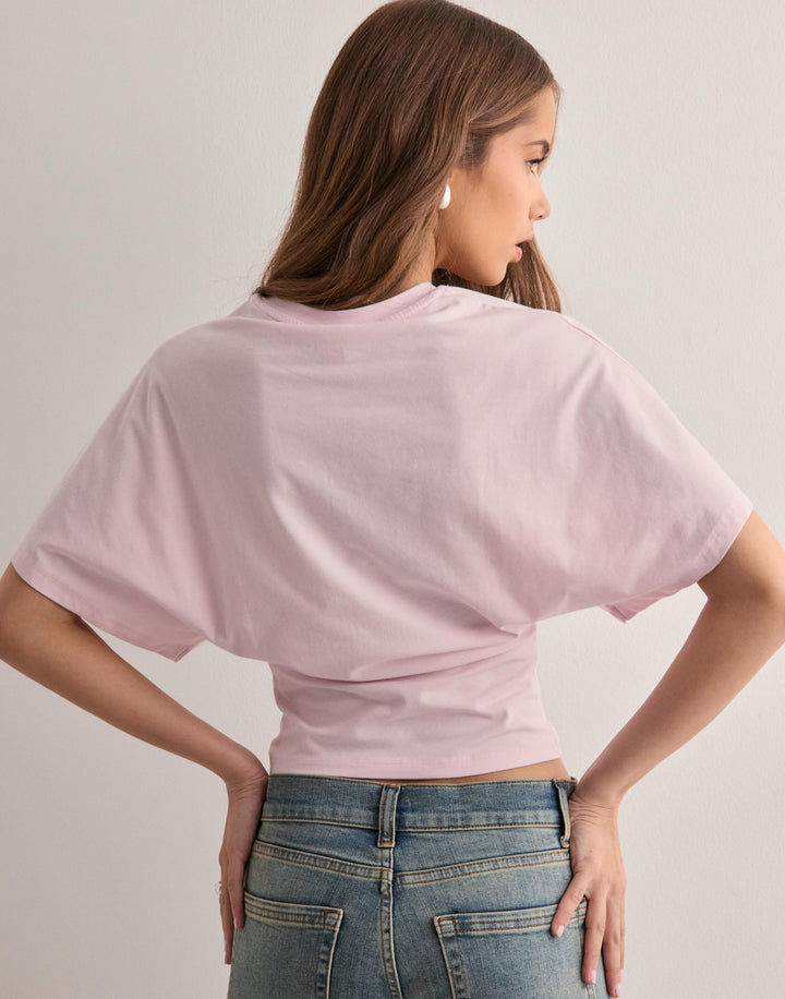 Female model back view wearing elegant flared sleeve shirt plain background