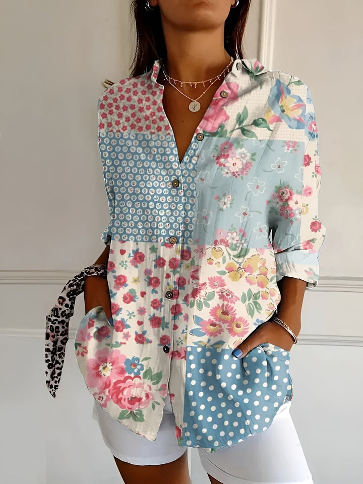 Female model in a relaxed summer floral blouse with a plain background.