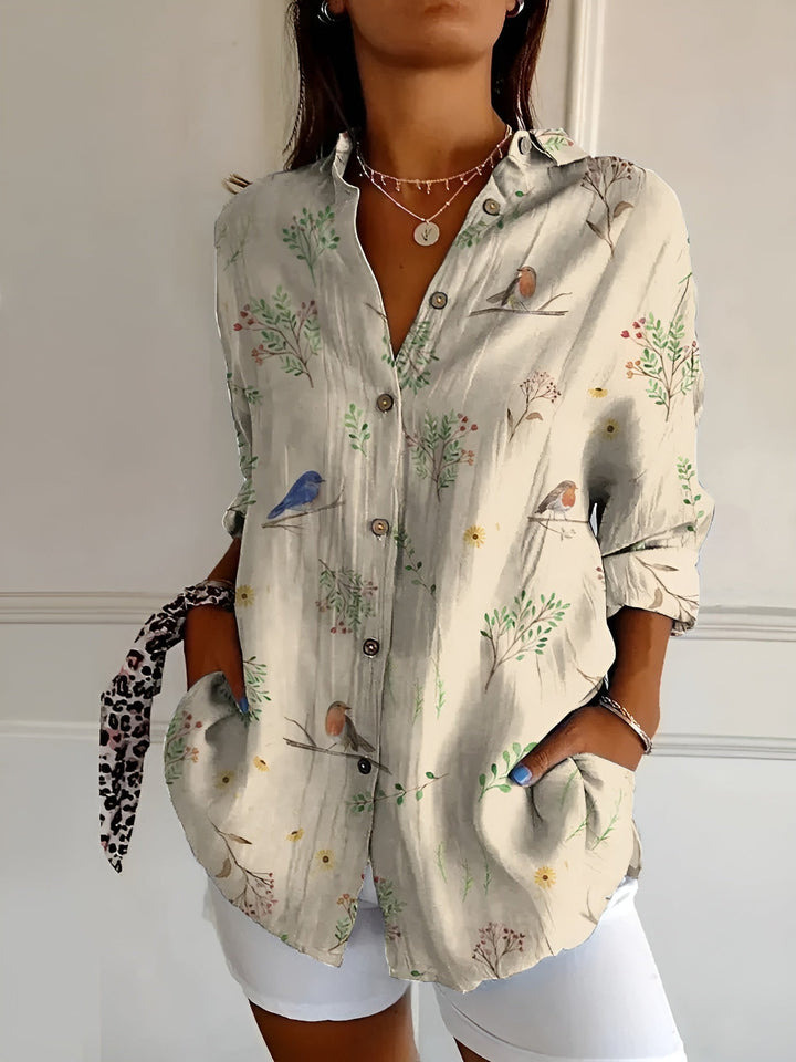 Woman model displaying a loose-fit floral summer top with a clean background.