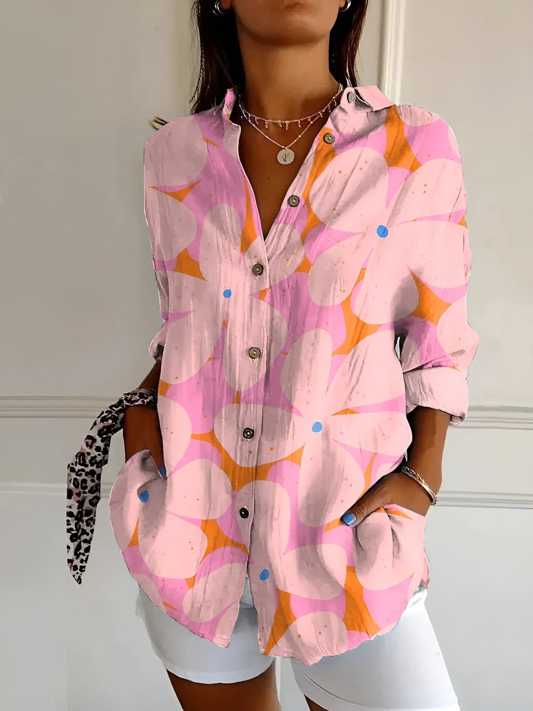 Female model wearing a bright floral blouse for casual summer styling.