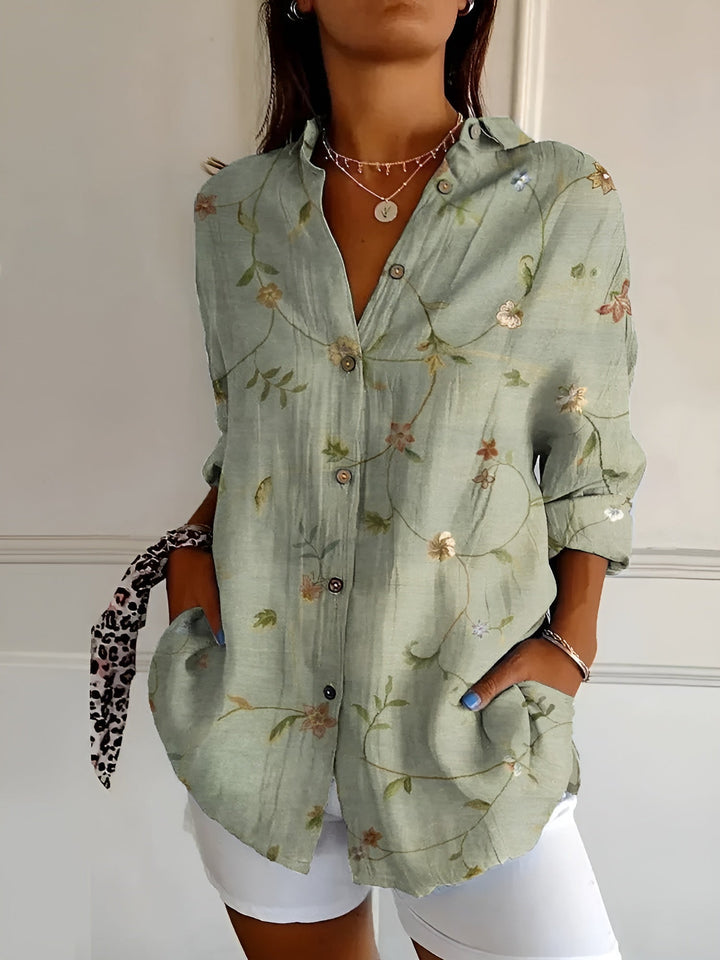 Woman model showcasing a vibrant floral blouse on a clean background.