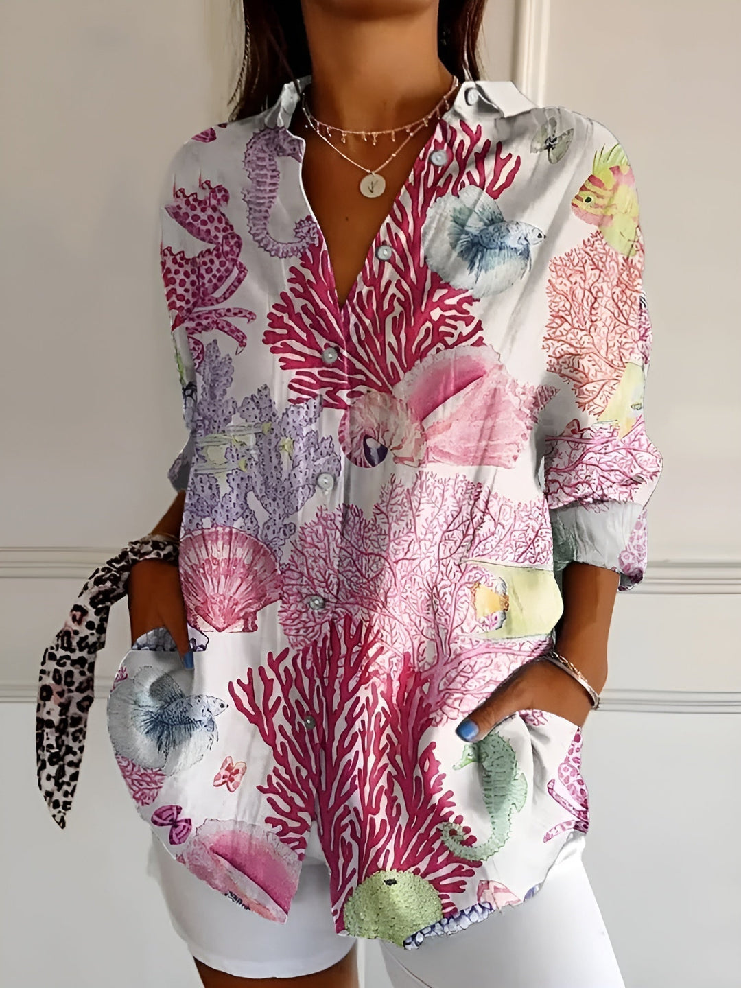 Woman model wearing a colorful button-front blouse against a clean background.