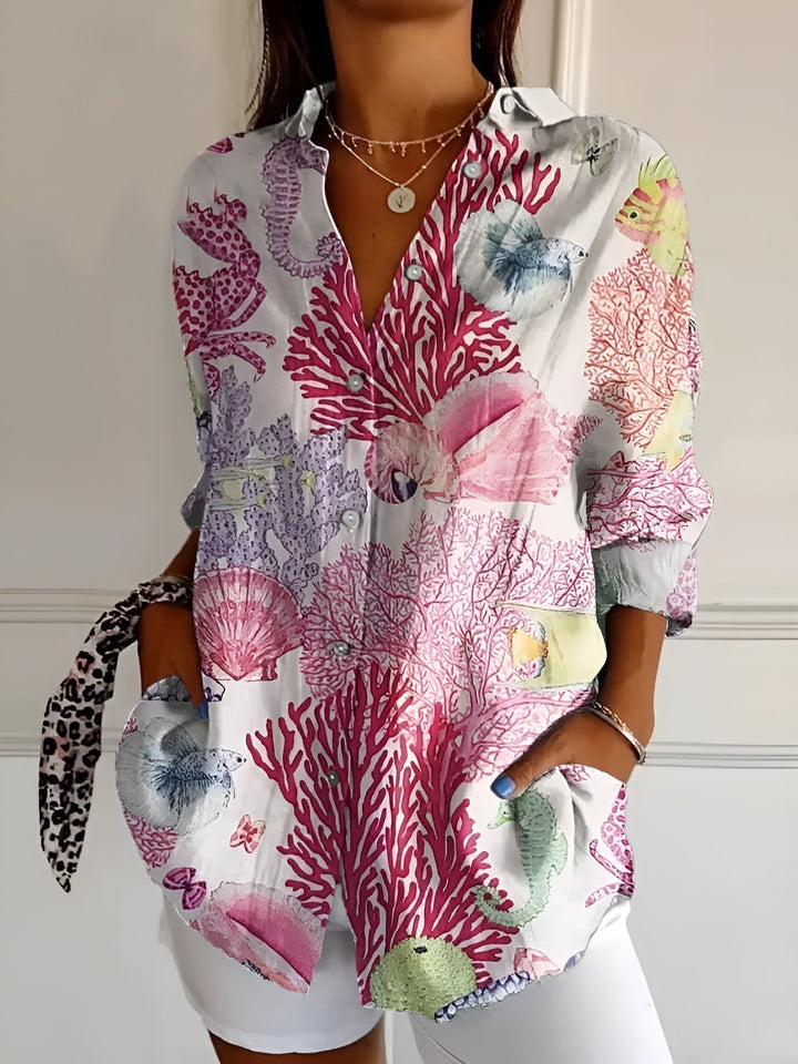Woman model wearing a colorful button-front blouse against a clean background.