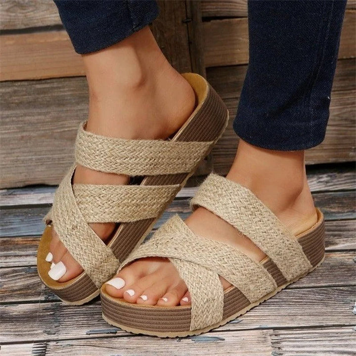  Female wearing summer platform sandals with textured straps on a plain background.