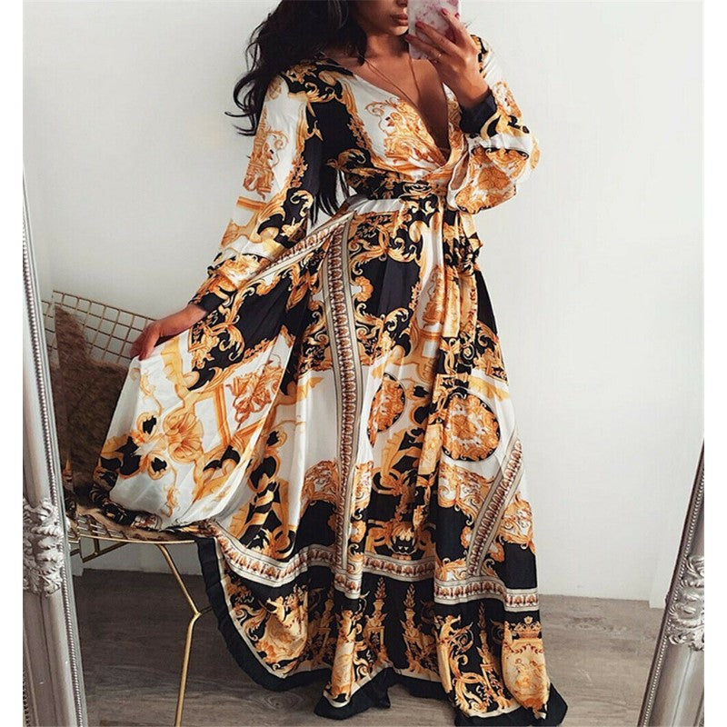 Model wearing a belted wrap maxi dress with vibrant print on a plain background.