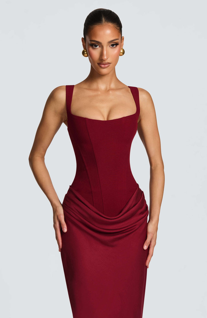 Woman wearing sleek maxi red dress gray background