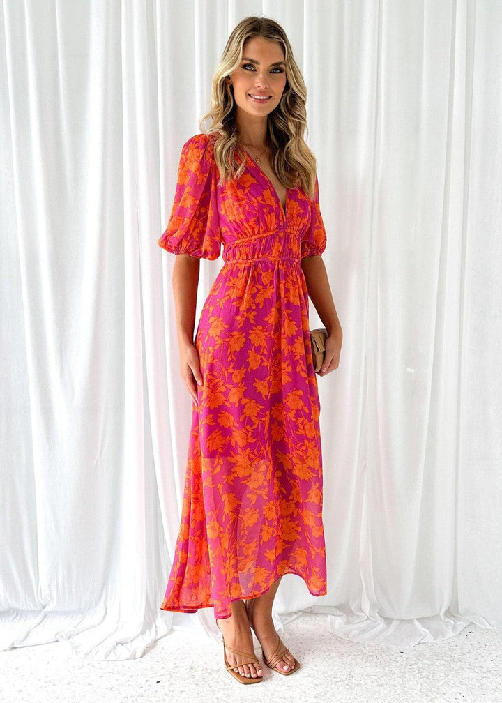 Female model showcasing a floral print maxi dress with elegant movement and a long flowing skirt.
