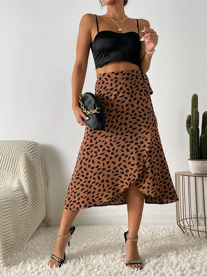Woman wearing a printed wrap tie skirt on a plain background.