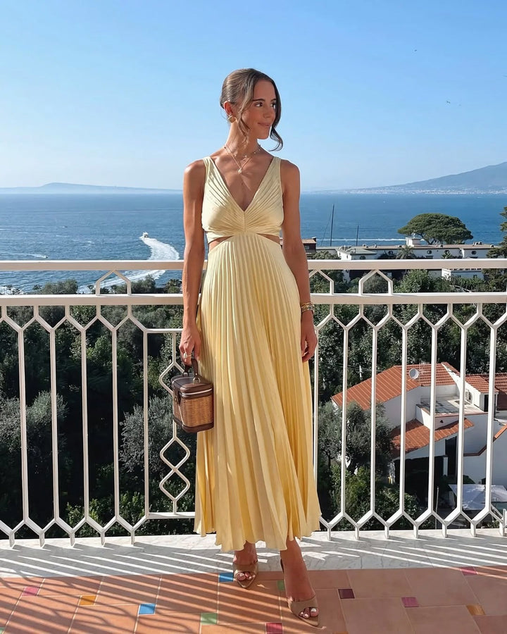 Female model wearing a pleated cutout waist midi dress against a plain background.