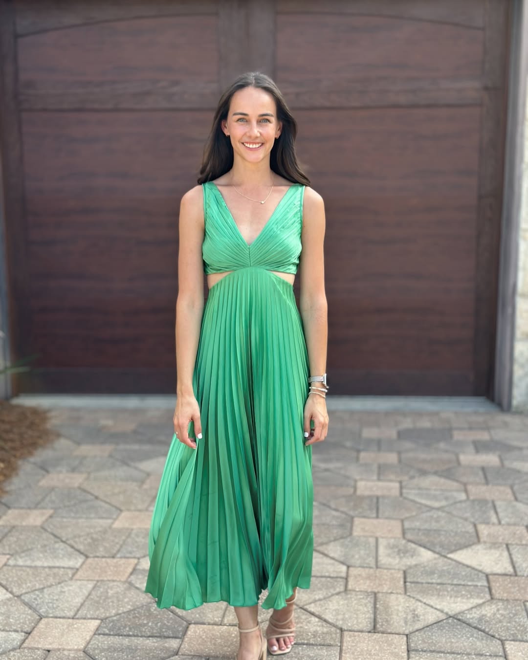 Woman wearing a pleated summer midi dress with a stylish cutout waist detail.