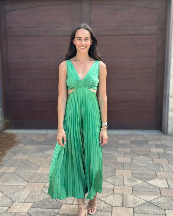 Woman wearing a pleated summer midi dress with a stylish cutout waist detail.