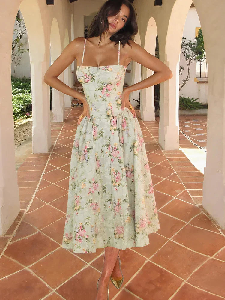 Female model wearing floral midi dress front view on nature background.