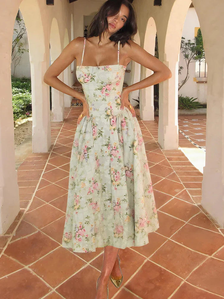 Female model wearing floral midi dress front view on nature background.