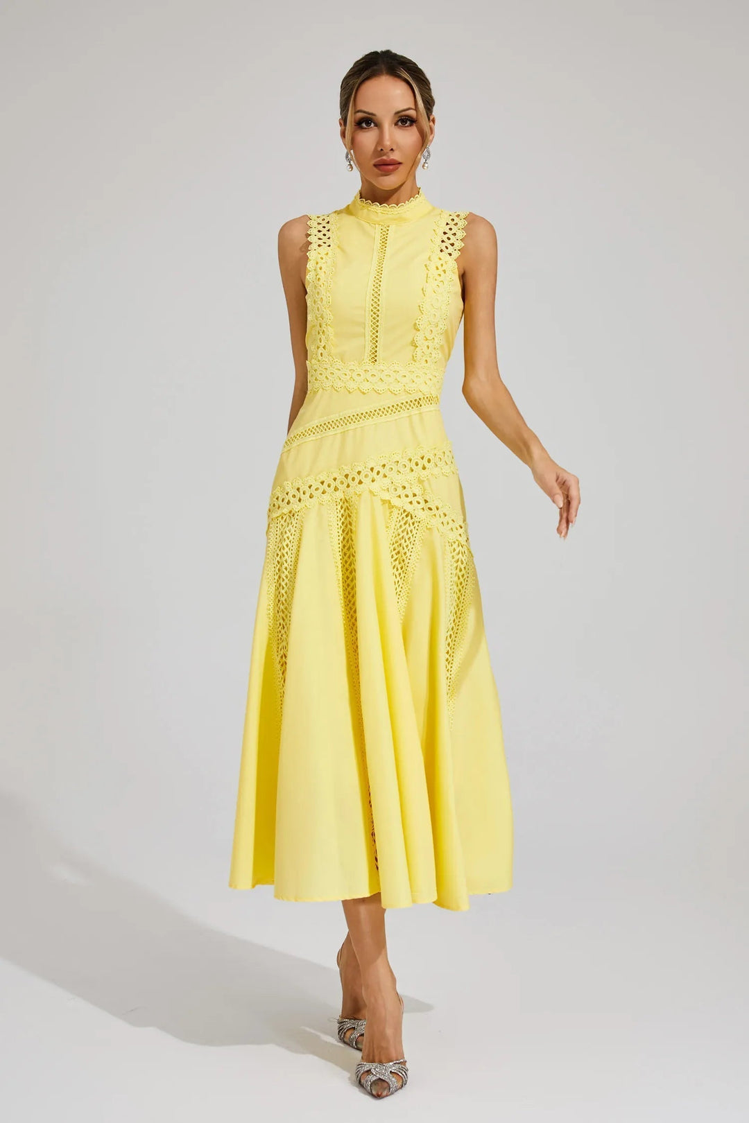Female model wearing elegant sleeveless midi dress on clean gray background.
