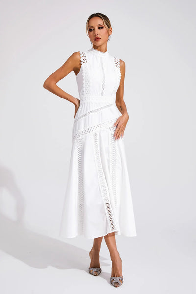 Woman posing front view in flowing midi dress on gray background.