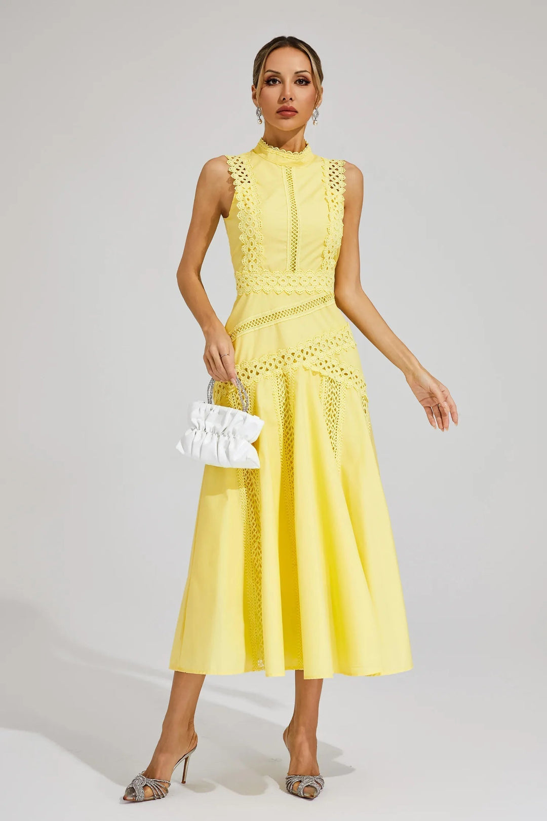 Female model in bright midi dress standing on clean background.