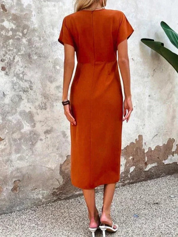 Female model displaying a wrap midi dress with a refined and feminine shape.