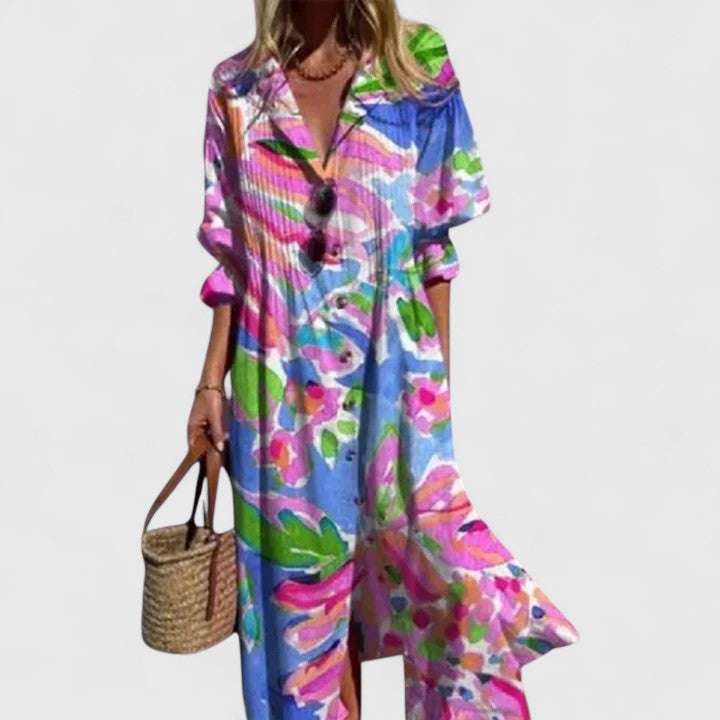 Woman posing in a flowy floral maxi dress with button-front detail.