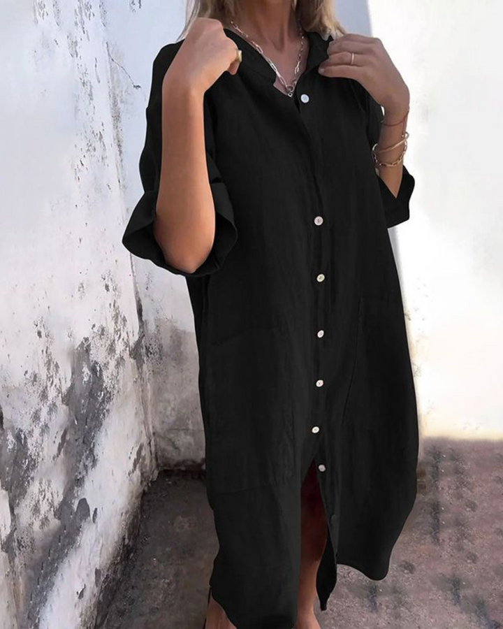 Model in a loose fit women’s shirt dress with pocket detail on a clean background.