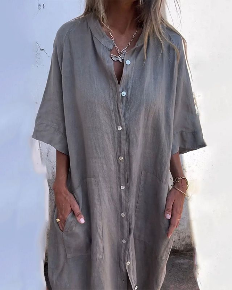 Woman model wearing a relaxed button-down midi shirt dress on a plain background.