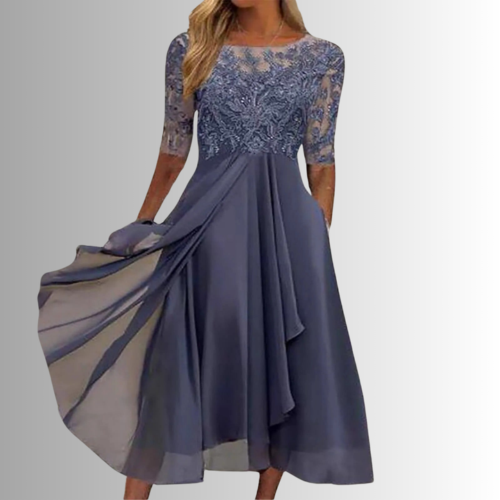 Woman model in a structured embroidered midi dress on a plain studio background.