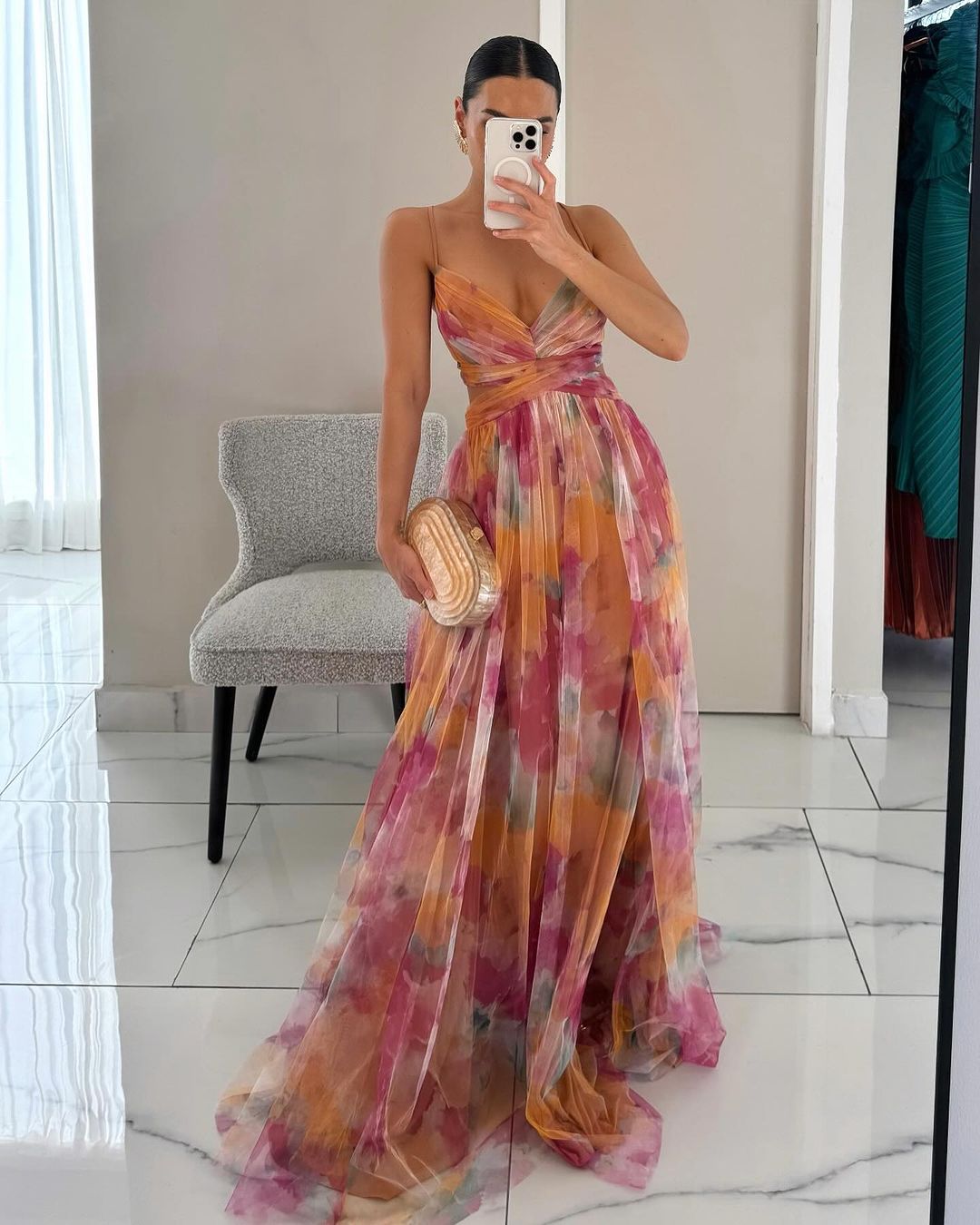 Woman model wearing a floral maxi dress on a plain background.