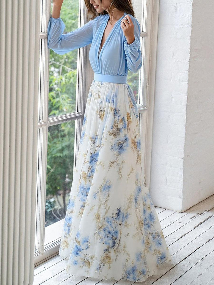 Female in a long sleeve floral maxi dress against a plain background.