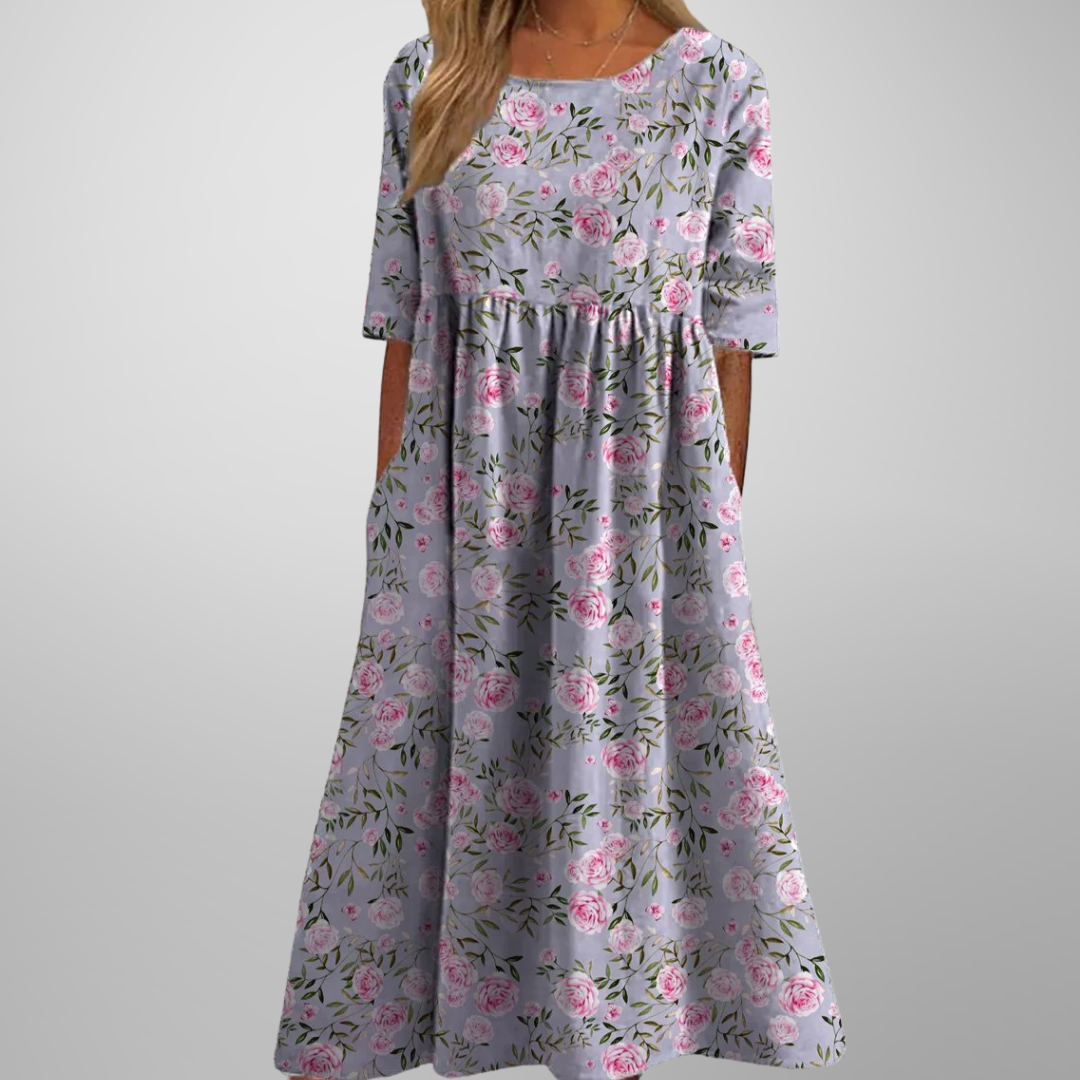 Woman model showcasing a women’s floral maxi dress with pockets on a plain background.