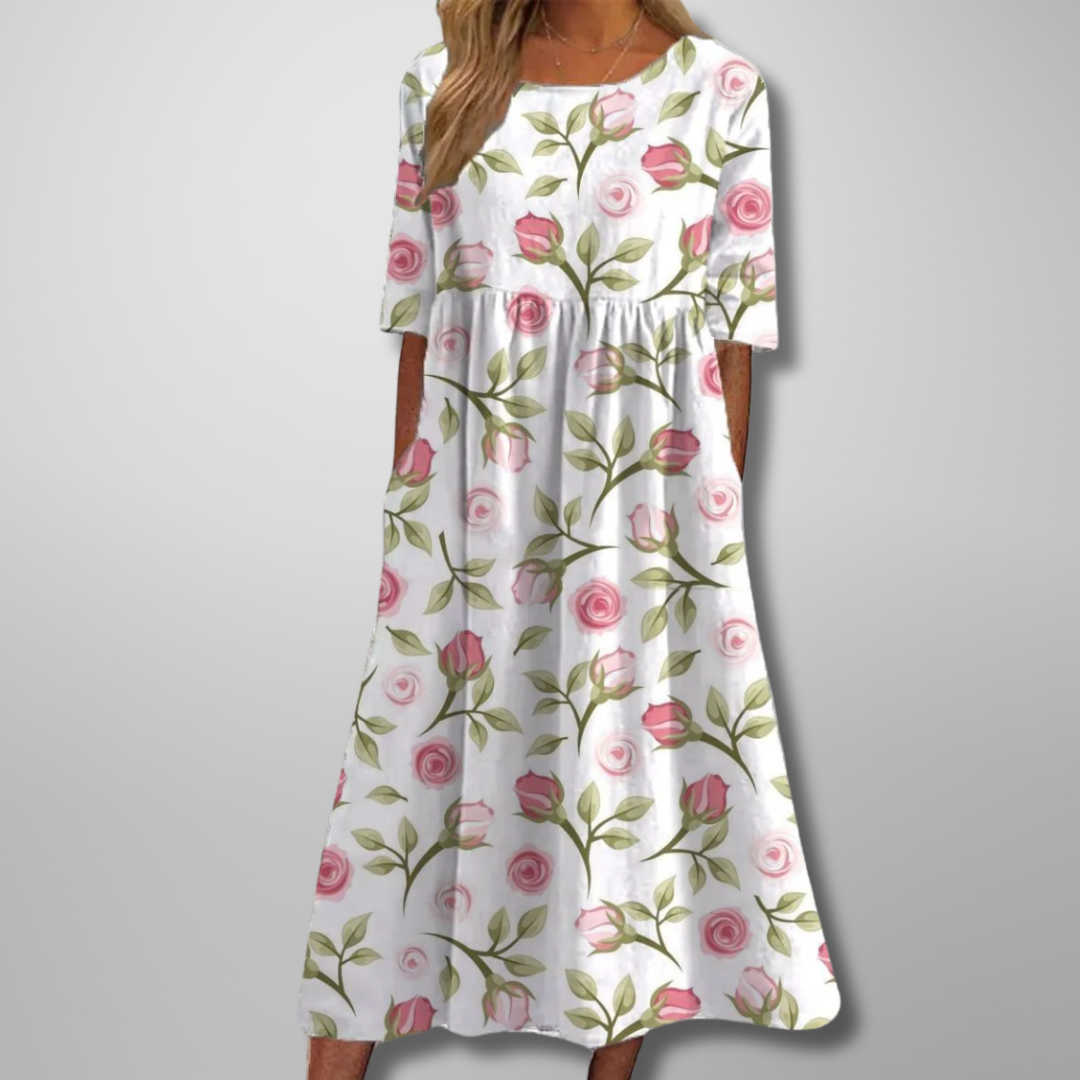Woman model in a breezy floral maxi dress with side pockets on a plain background.