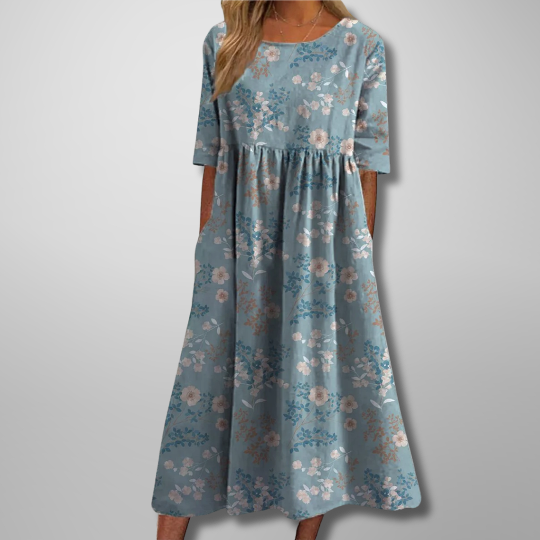 Woman model wearing a soft floral print maxi dress with relaxed fit on a clean background.