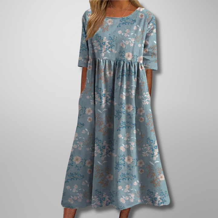 Woman model wearing a soft floral print maxi dress with relaxed fit on a clean background.