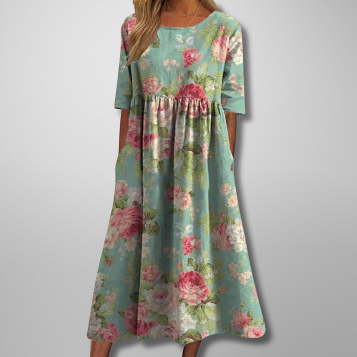 Model in a relaxed floral maxi dress with 3/4 sleeves on a clean background.