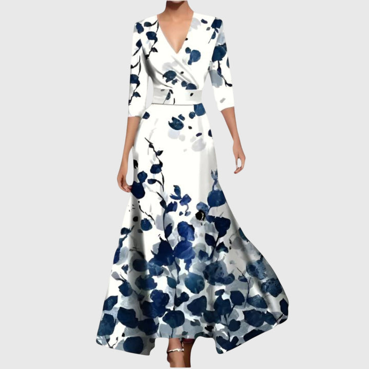 Woman model wearing an elegant floral maxi dress on a plain backdrop.