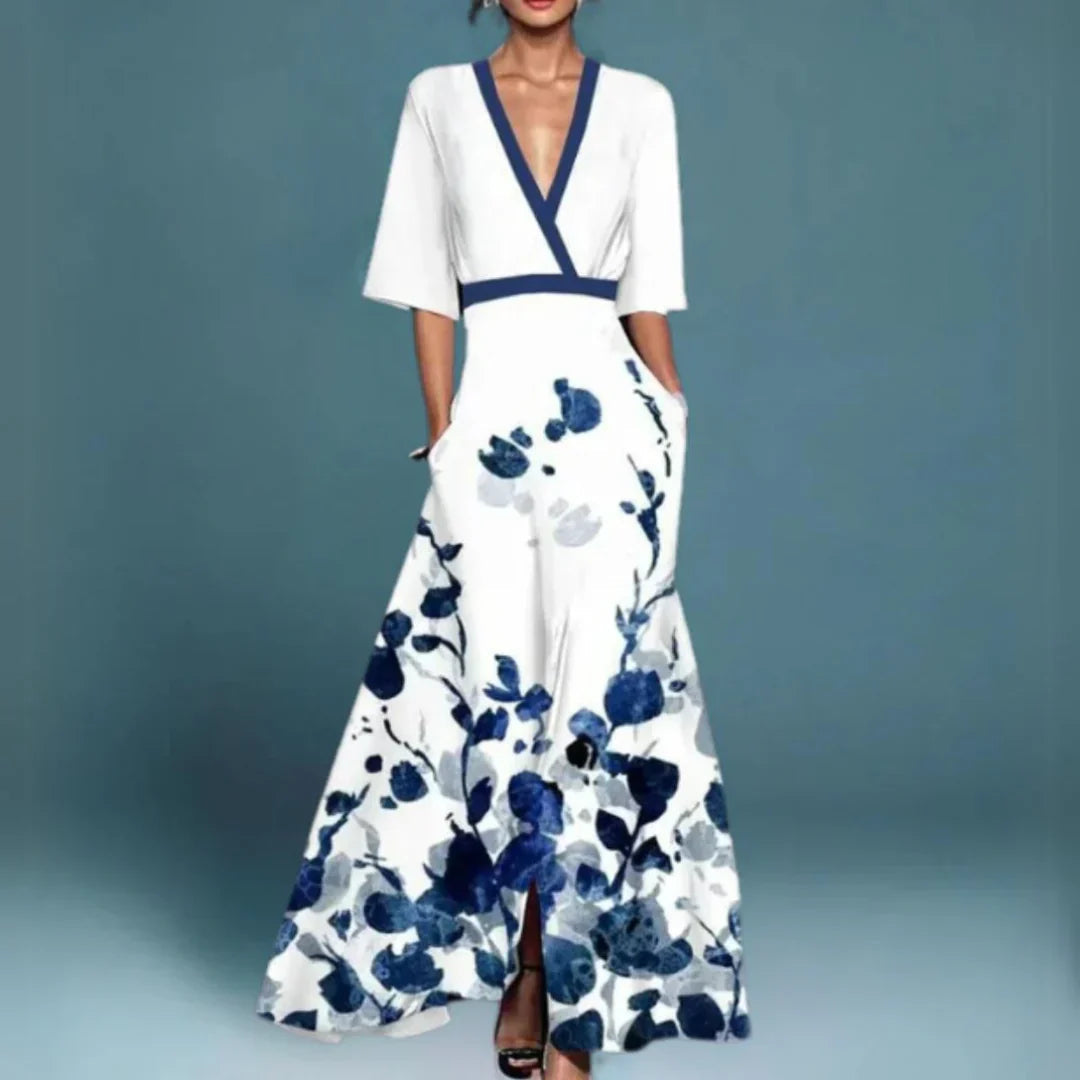 Female model in a floral V-neck maxi dress with short sleeves on a plain background.