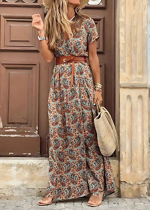 Stylish floral wrap maxi dress displayed on a woman model by a wooden wall.
