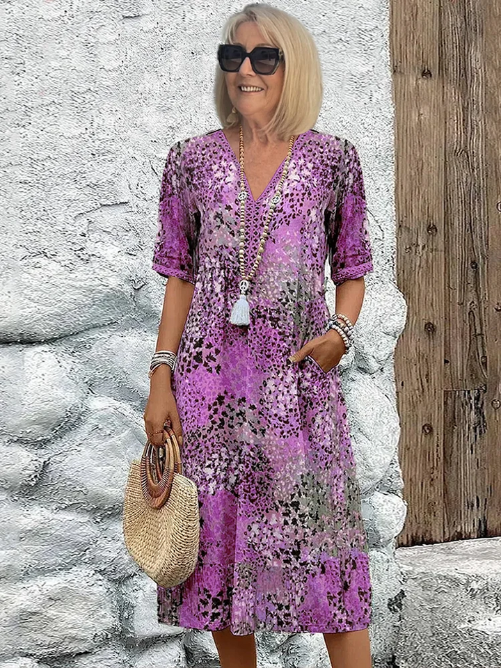 Woman model wearing a comfortable V-neck midi dress with a relaxed fit on a plain background.