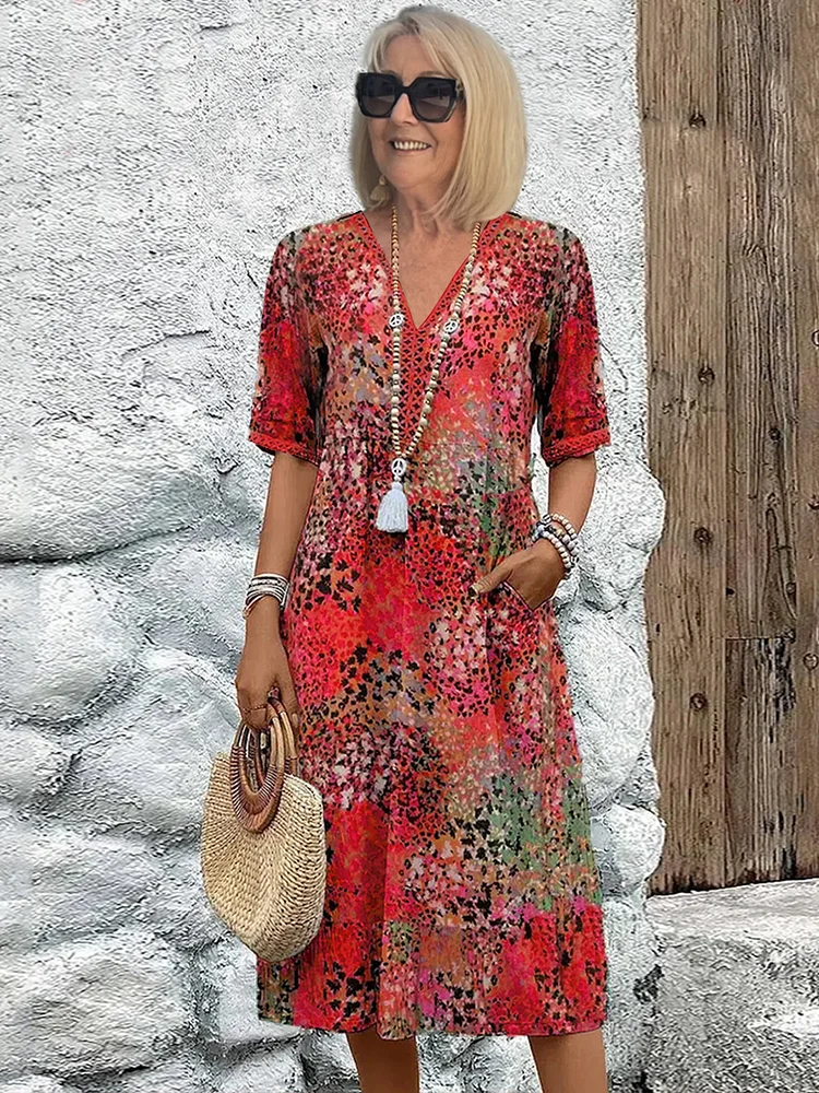 Woman model wearing a printed midi dress with a flattering V-neck on a clean background.