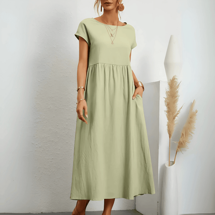 Model posing in a flattering A-line dress on a plain background.