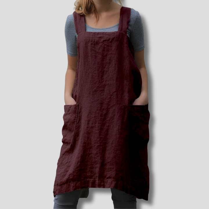 Woman wearing an everyday sleeveless apron midi dress against a clean backdrop.