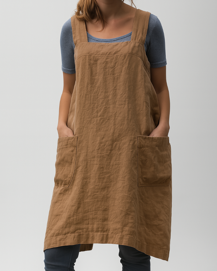 Model in a relaxed fit apron midi dress on a clean background.