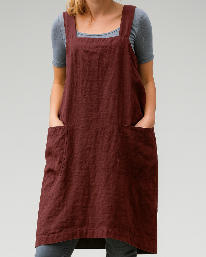 Woman model wearing a sleeveless apron midi dress against a plain background.