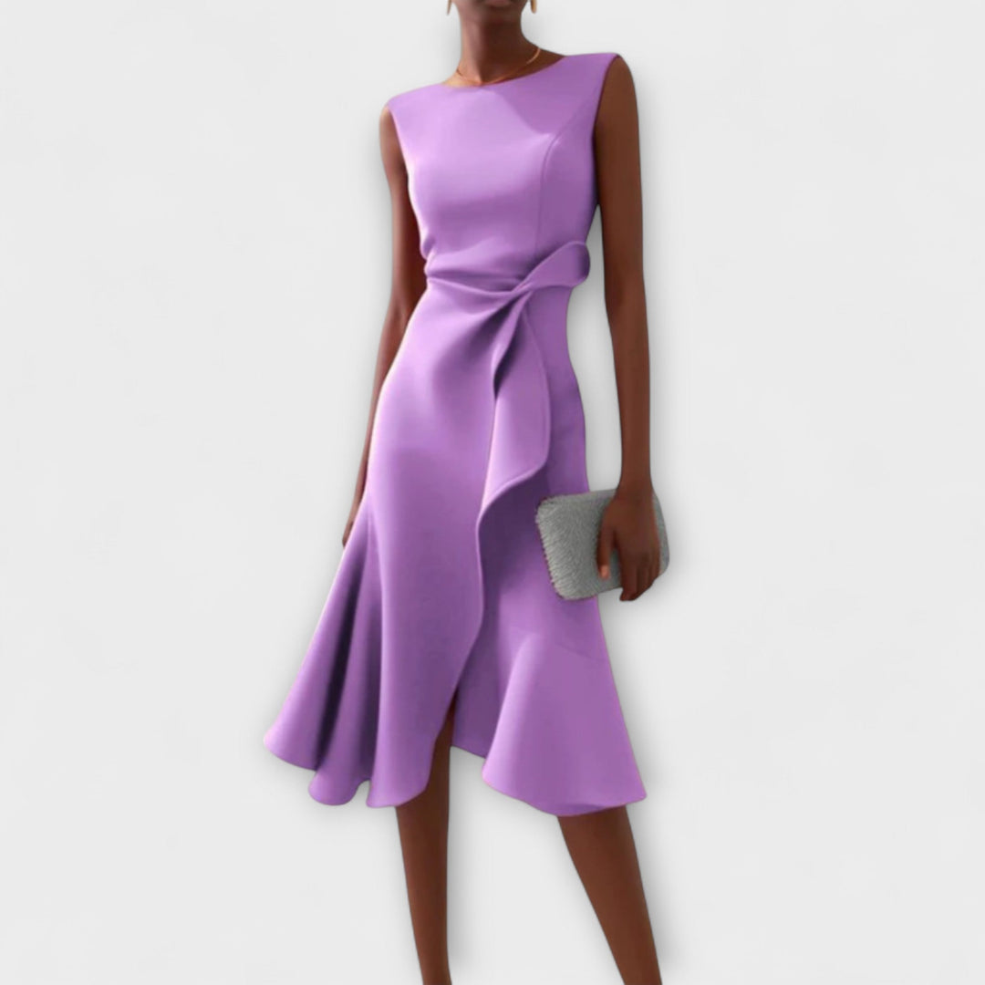 Woman model displaying a modern sleeveless wrap dress on a minimal background.