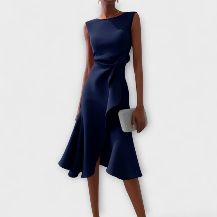 Model posing in a flattering wrap midi dress with a plain background.